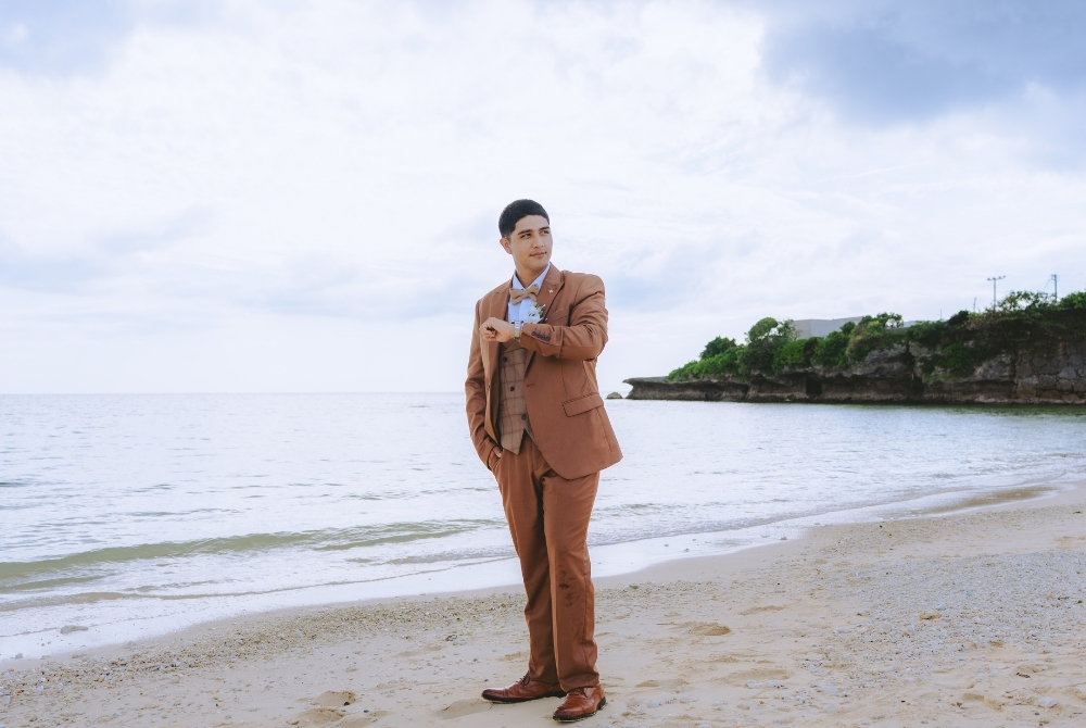 Solo shot of the groom in brown tuxedo