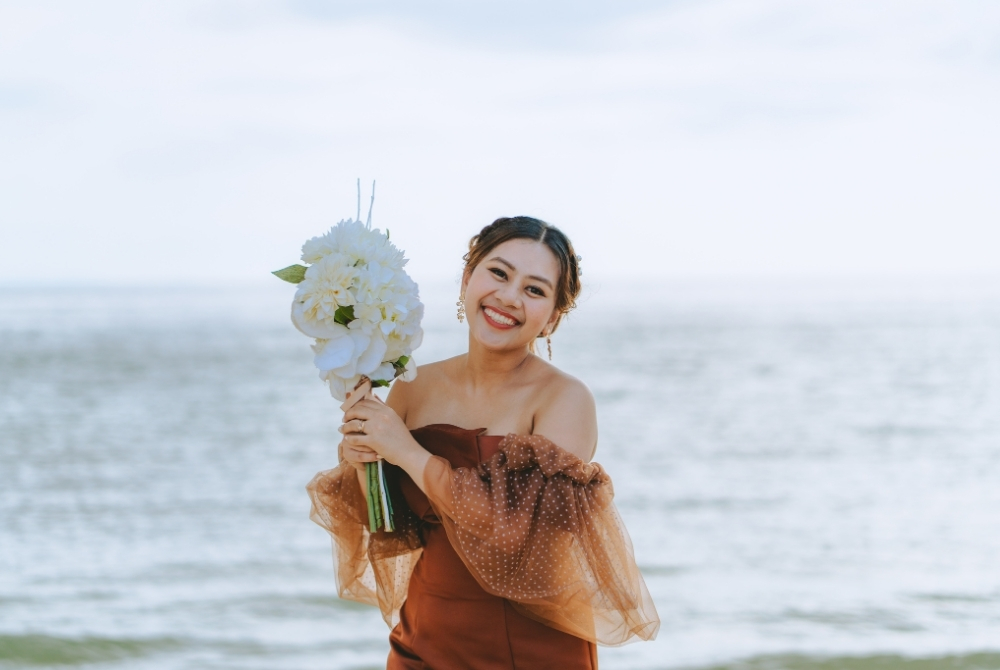 Solo shot of the smiling bride with her bouquet