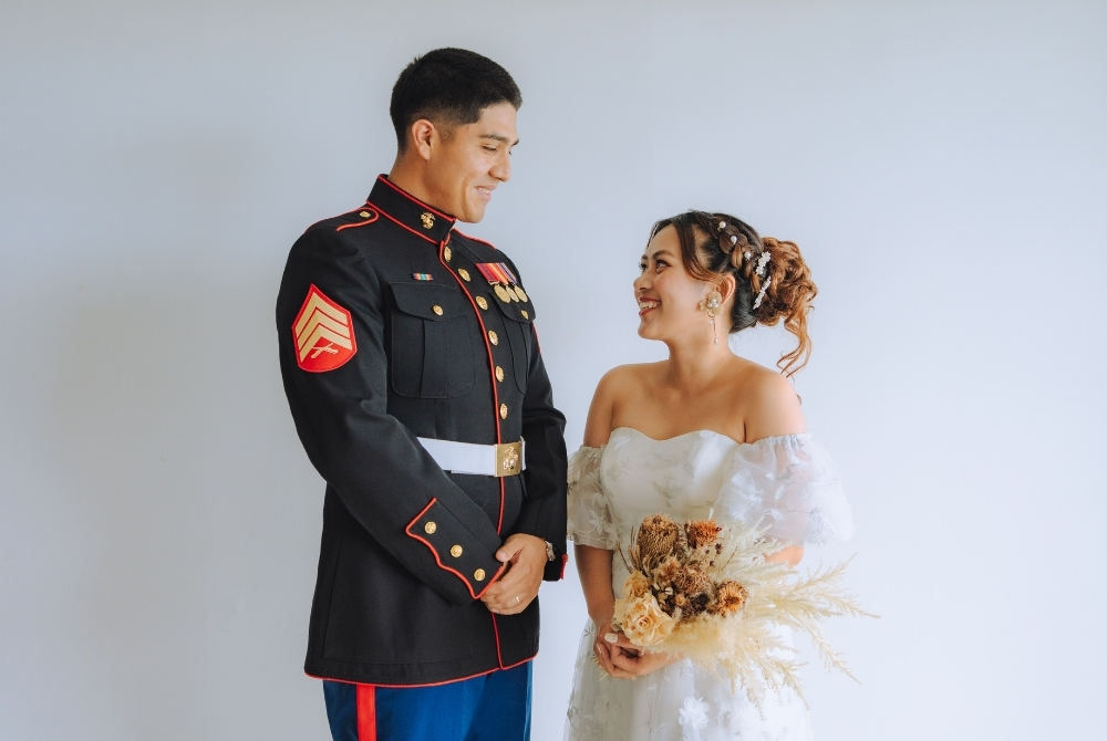 a groom in his uniform and a bride in white dress